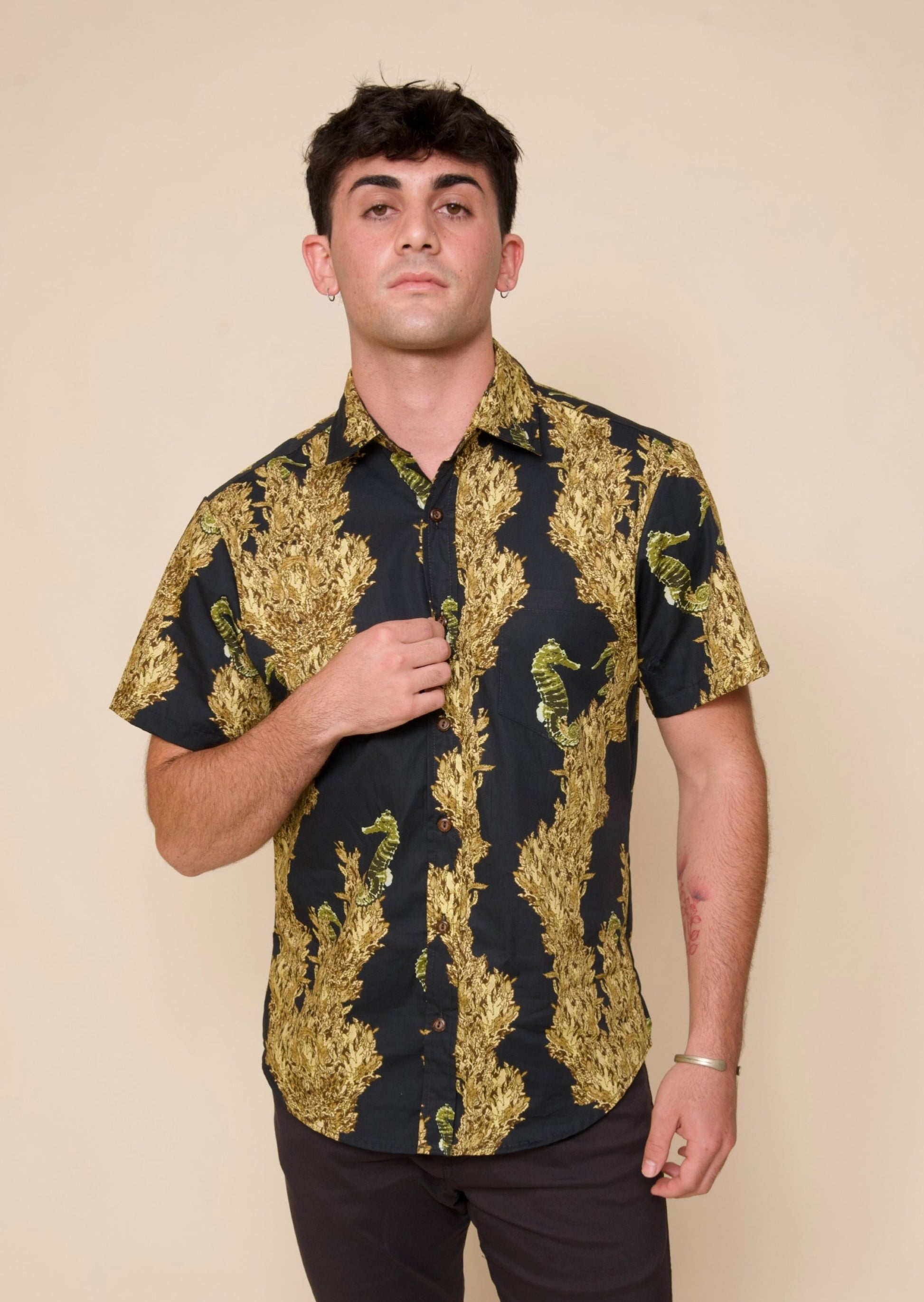 Man wears Mens short-sleeve Black & Gold Aloha Shir